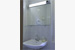 Badezimmer im Bungalow mit Waschbecken, Spiegel, Fenster und Dusche.